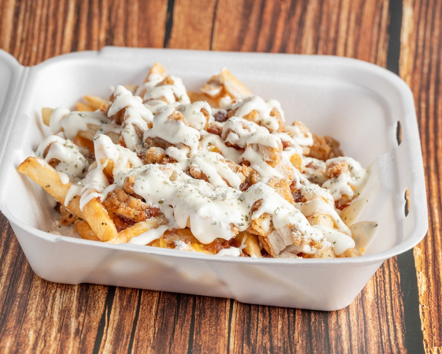 Loaded fries covered in toppings and creamy sauce
