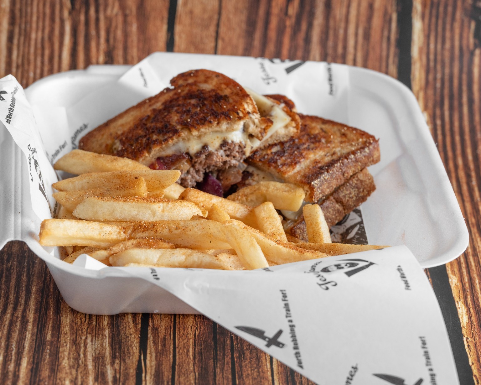 A grilled sandwich served with fries