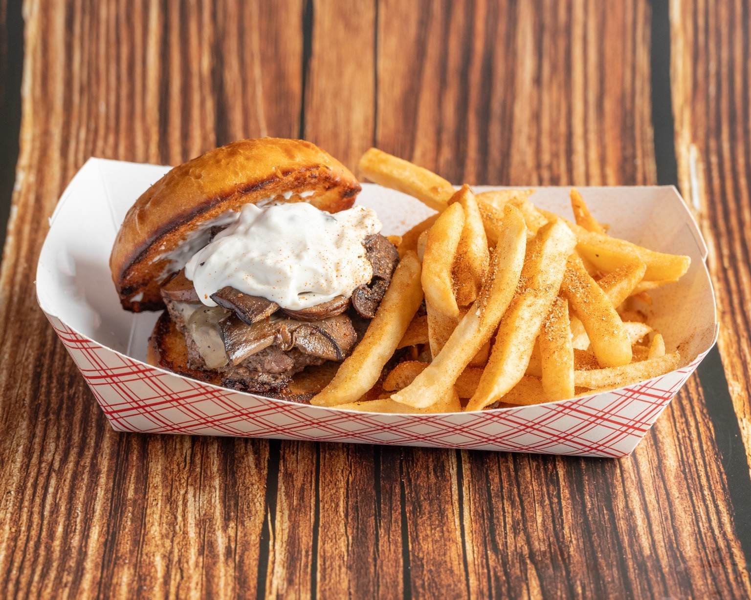 A burger piled with toppings alongside golden fries